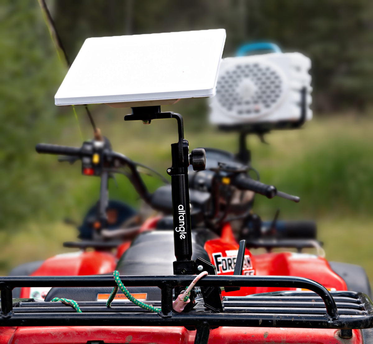 Starlink Mini raised on an Altangle Connect mount above the front rack of a red ATV, with a portable speaker mounted alongside