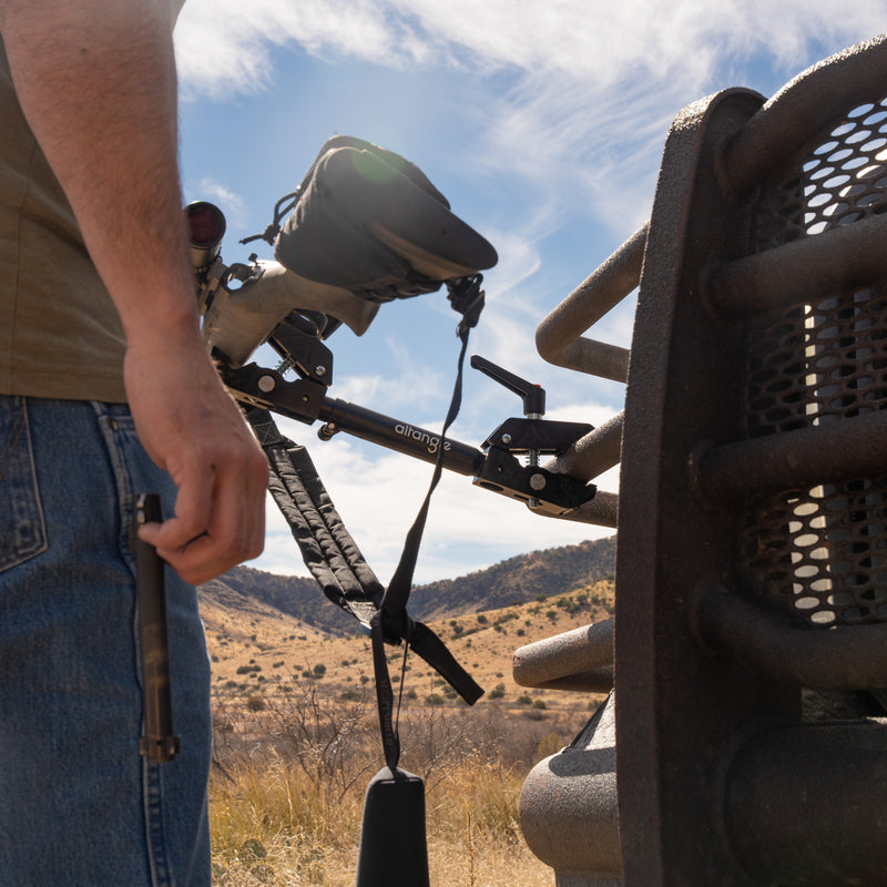 Connect Pro clamped to a vehicle grill guard holding a rifle in the field