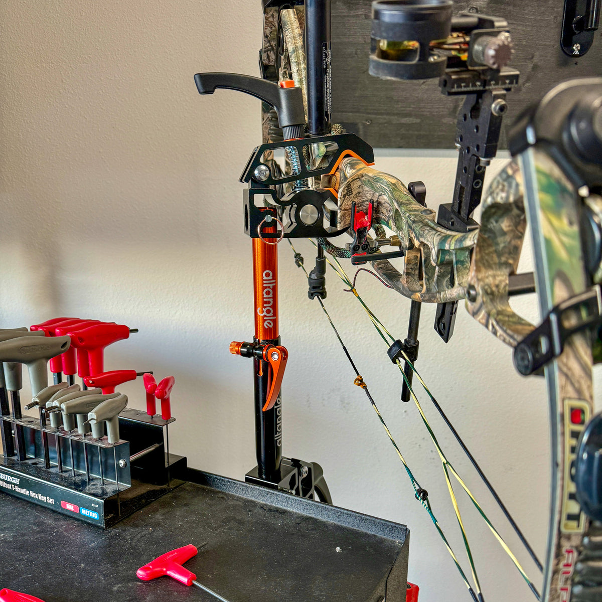 Connect Pro clamped to a workbench holding a camo compound bow for tuning