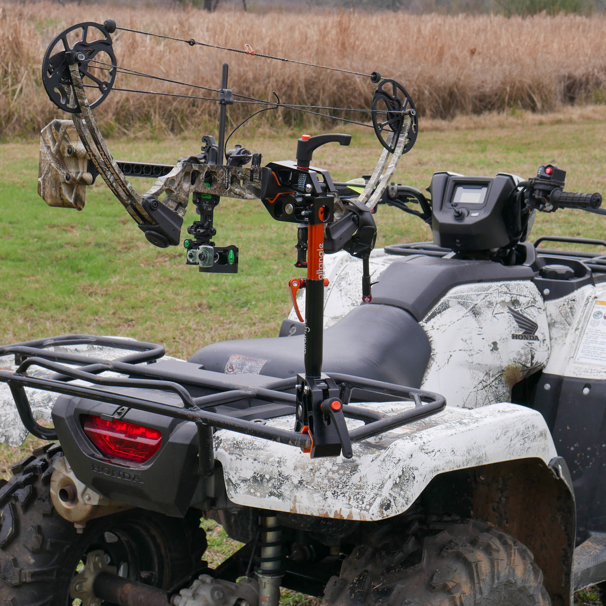 Connect Pro mounted to an ATV rear rack carrying a camouflage compound bow across the field
